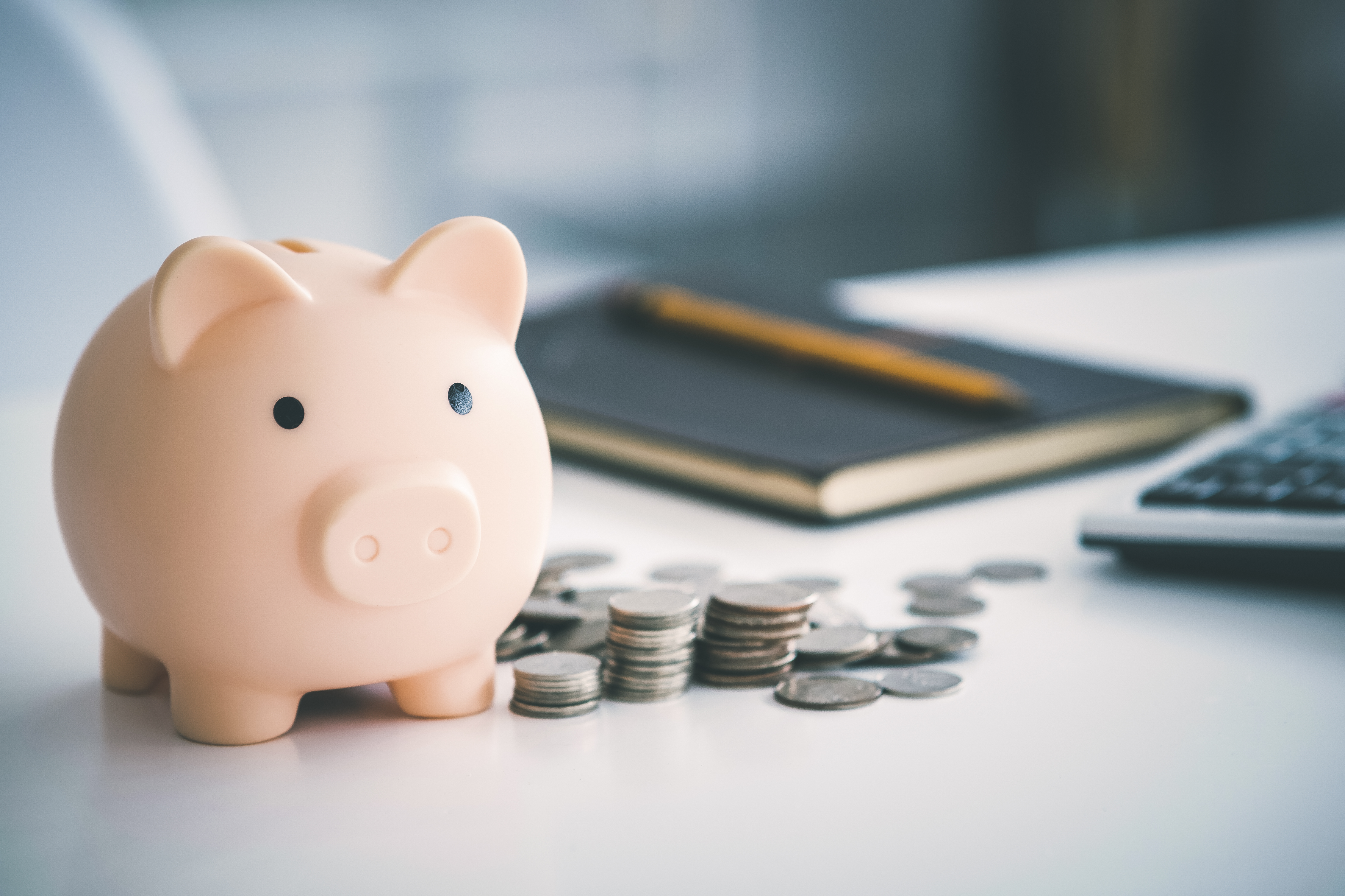 A piggy bank with coins next to it.